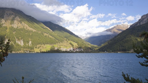 View over Lake Reschen to the village of Graun in Vinschgau, which is beautifully situated in the valley of the surrounding mountains