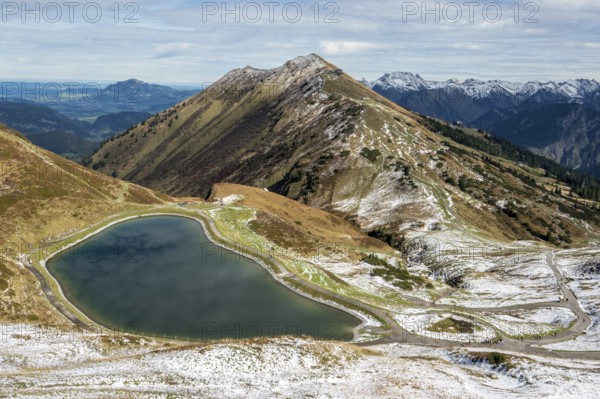 Reservoir, Kanzelwand snow-making pond, behind Fellhorn and mountains of the Allgäu Alps, Vorarlberg, Austria