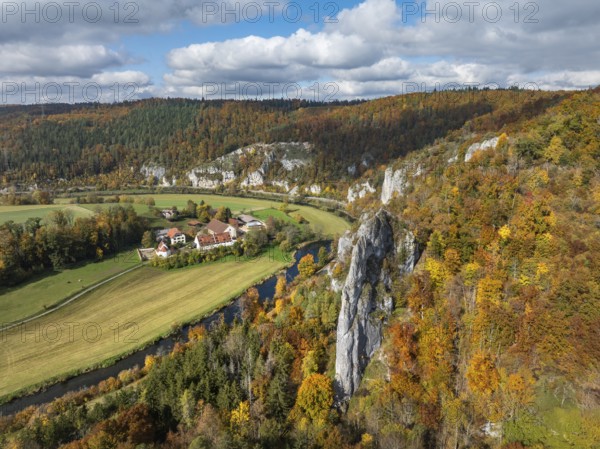 Aerial view of Käppeler Manor with St. George's Basilica near Thiergarten in the Upper Danube Valley, surrounded by autumn vegetation, on the right the raven rocks, climbing rocks, Jura limestone rocks, Sigmaringen district, Baden-Württemberg, Germany