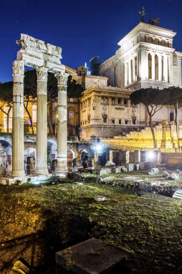 Forum of Caesar (Foro di Cesare), built between 1st century BC and 2nd century AD, with the colums of the Temple of Venus Genetrix in front and the Monument to Vittorio Emanuele II in the background, at night. Rome, Province of Rome, Italy