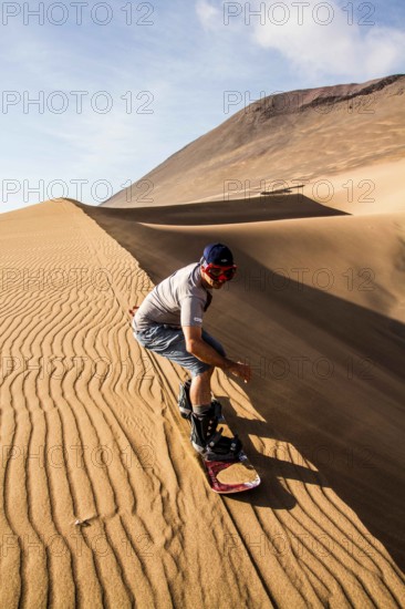 Sandboarding on Caramucho dunes, in Atacama Desert. Iquique, Tarapaca Region, Chile. 21.11.15