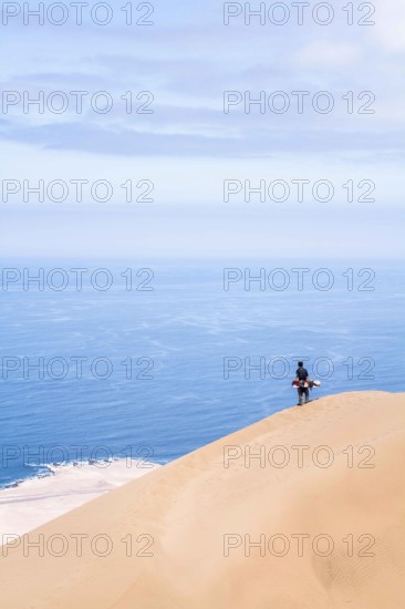 Young man looking at the view from Alto los Verdes, in Atacama Desert. Iquique, Tarapaca Region, Chile. 19.11.15