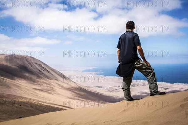 Young man looking at the view from Alto los Verdes, in Atacama Desert. Iquique, Tarapaca Region, Chile, 19.11.15