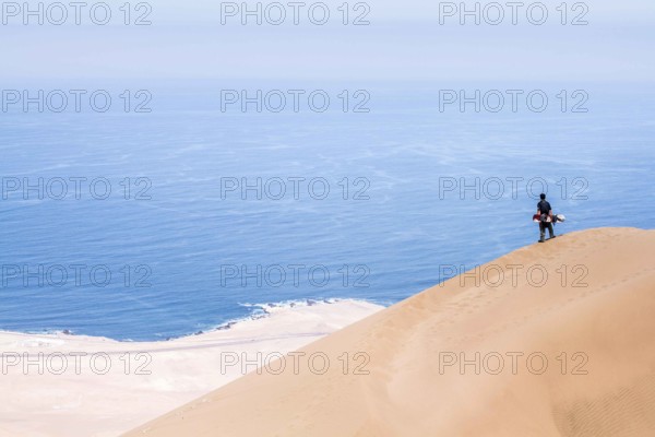 Young man looking at the view from Alto los Verdes, in Atacama Desert. Iquique, Tarapaca Region, Chile. 19.11.15