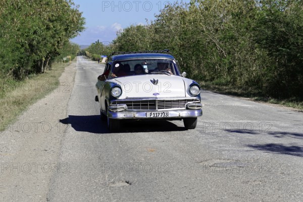 American classic car from the 1950s, near Holguin, Cuba, vintage classic car driving on a rural road under a blue sky, Greater Antilles, Caribbean, Central America, America, Central America