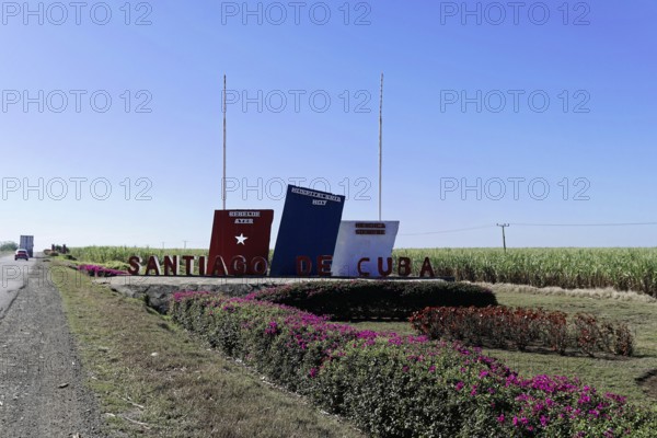 Sign with the word 'Santiago de Cuba' on a field with blue sky, Cuba, Greater Antilles, Caribbean, Central America, America, Central America