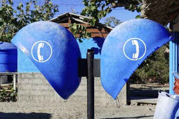 Baracoa, Cuba, Central America, Two blue public telephone boxes under bright sunshine, in front of a concrete wall, Greater Antilles, Caribbean, America, Central America