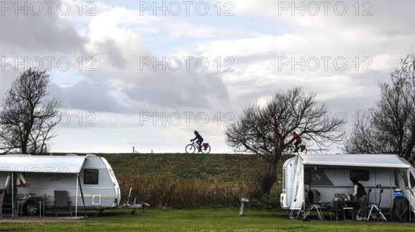 Caravan and motorhome on a campsite, a cyclist drives across the dike on the Baltic Sea, Fehmarn, 16.10.2025, Fehmarn, Schleswig-Holstein, Germany