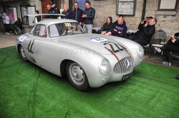 Silver Mercedes gullwing door with race number in a narrow alley at a classic car rally, spectators up close, Mille Miglia 2016, time control, checkpoint, SAN MARINO, classic car race. San Marino, Italia