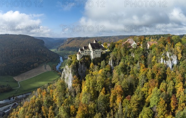 Aerial view of Werenwag Castle and former Werenwag Castle on a rocky spur in the Upper Danube Valley, surrounded by autumnal vegetation and clouds of fog, Sigmaringen district, Baden-Württemberg, Germany
