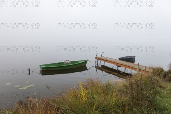 Two boats and a jetty in autumnal, foggy surroundings, Hopfensee, Ostallgäu, Bavaria, Germany
