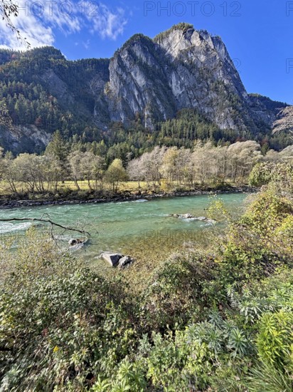 A fast-flowing river in an autumnal mountain landscape, surrounded by trees and rocks, Lienz Dolomites, Drau, Lienz, Tyrol, Austria