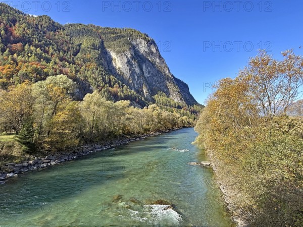 A clear river that snakes through an autumnal mountain landscape, under a clear sky, Drau, Drau cycle path, near Lienz, Tyrol, Austria