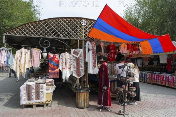 Market stand with traditional clothing and colorful textiles under the Armenian flag, Vernissage Market, Crafts Market, Yerevan, Yerevan, Yerevan, Armenia