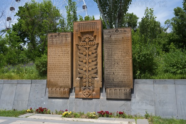 Detailed stone monuments in the open air and surrounded by trees, memorial plaques on Heroes' Alley in Victory Park, Haghtanak Park, Yerevan, Yerevan, Armenia