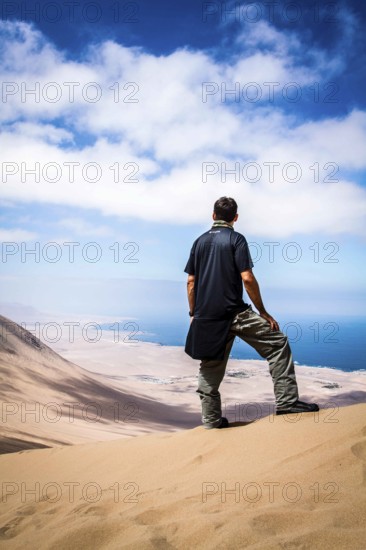 Young man looking at the view from Alto los Verdes, in Atacama Desert. Iquique, Tarapaca Region, Chile. 19.11.15