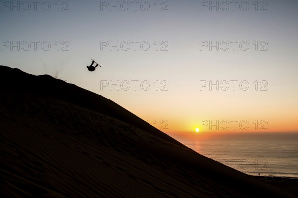 Sandboarding in Cerro Dragon, a sand dune located next to the city of Iquique, in Atacama Desert. Iquique, Tarapaca Region, Chile. 15.11.15