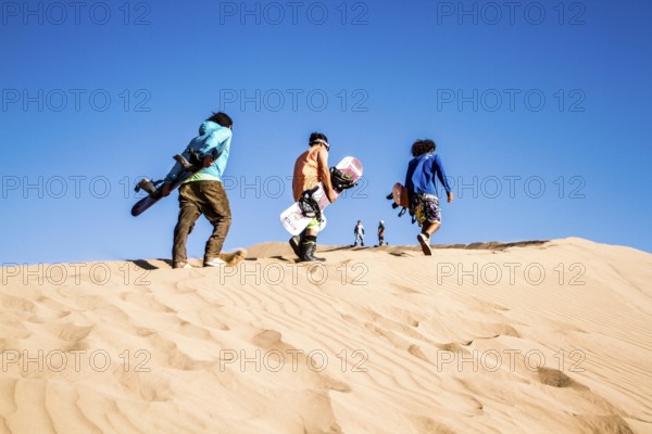 Sandboarding in Cerro Dragon, a sand dune located next to the city of Iquique, in Atacama Desert. Iquique, Tarapaca Region, Chile