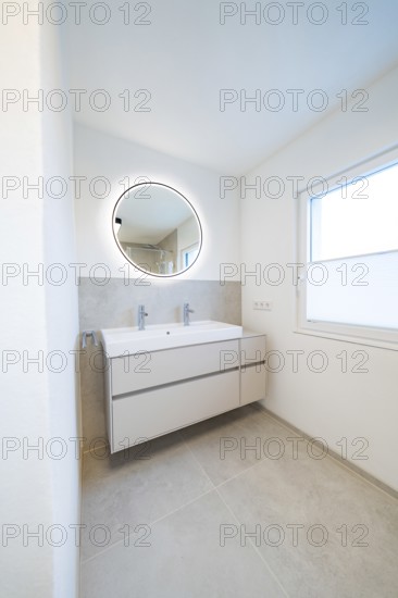 Minimalistic washing area with round LED mirror, double sink and large window, house renovation, energy renovation, Metzingen, Germany