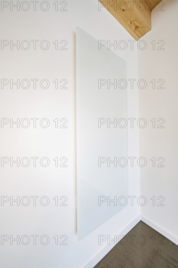 Large white glass wall panel in a bright room with wooden beam ceiling, house renovation, energy renovation, Metzingen, Germany