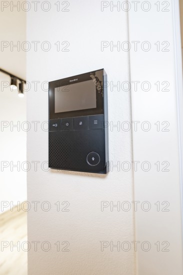 Black video intercom system with display on white wall in modern entrance area, house renovation, energy renovation, Metzingen, Germany