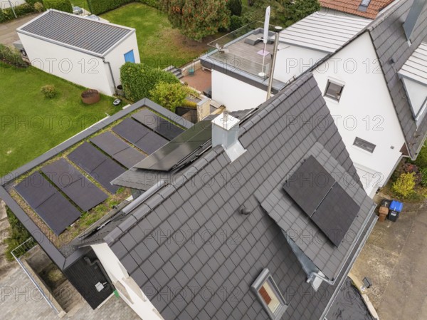 Aerial view of a modern house with PV on roof and carport with green roof, surrounded by gardens and neighboring houses, house renovation, energy renovation, Metzingen, Germany
