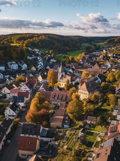 A village with a church in autumn, surrounded by colorful trees and hills, Deufringen, Aidlingen, Böblingen district, Germany