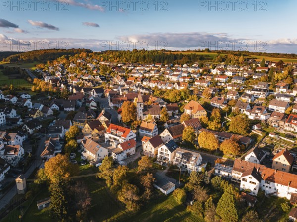 A picturesque village with colorful roofs and autumn trees under a blue sky, Deufringen, Aidlingen, Böblingen district, Germany