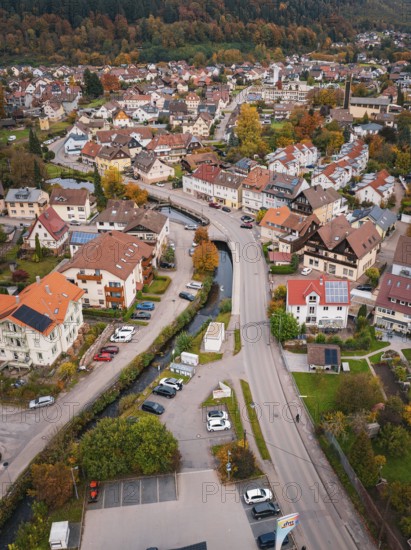 A bird's eye view of a village, showing narrow roads, lots of houses, autumn trees and cars, Calmbach, Bad Wildbad, Black Forest, Germany