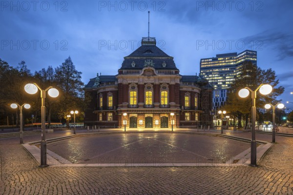 Laeiszhalle, formerly Musikhalle Hamburg, at Johannes Brahms Platz at Blue Hour with light clouds in the background and street lights in the foreground, Hamburg, Germany