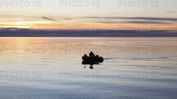 An angler docks on the shore with his inflatable boat and dog, Fehmarn Island, 18.10.2025, Fehmarn, Schleswig-Holstein, Germany