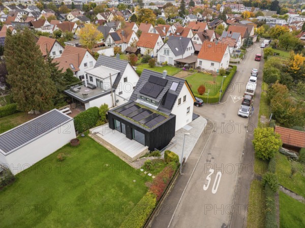 Overview of a quiet residential area with modernized house with solar system and dark extension on a Tempo 30 road, house renovation, air conditioning renovation, Metzingen, Germany