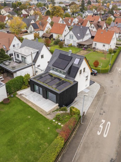 Aerial view of a house on a Tempo 30 road with PV on the roof and a green extension, with a spacious garden, house renovation, air conditioning, Metzingen, Germany