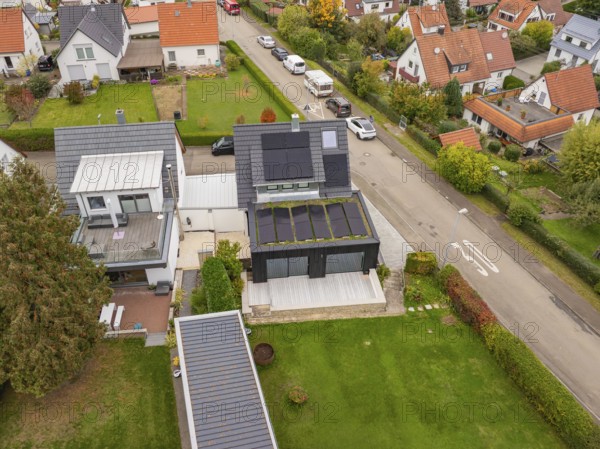 Vertical aerial view highlights the spacious wooden terrace at the extension and the orderly garden design, house renovation, climate renovation, Metzingen, Germany