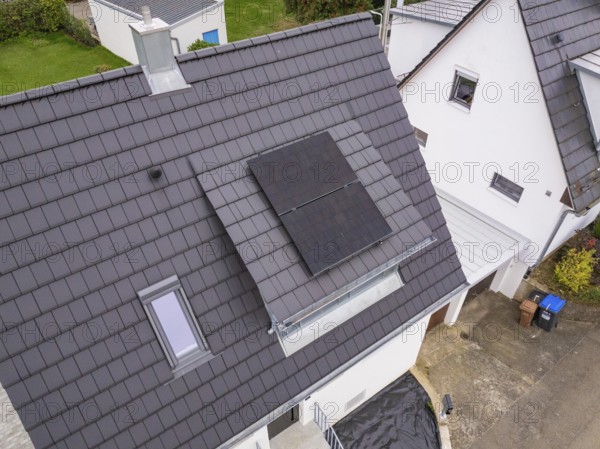Close-up of gable roof with two solar panels on a dormer with glass balustrade next to a skylight, house renovation, climate renovation, Metzingen, Germany