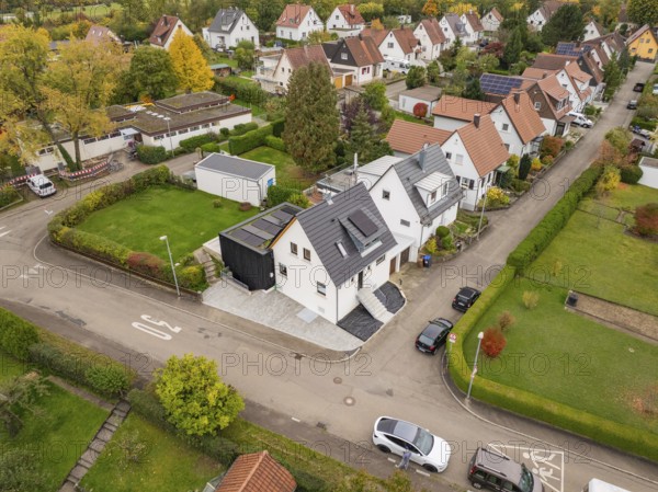 Wide angle aerial view of a quiet settlement with modernized house between well-kept gardens and autumn leaves, house renovation, climate renovation, Metzingen, Germany