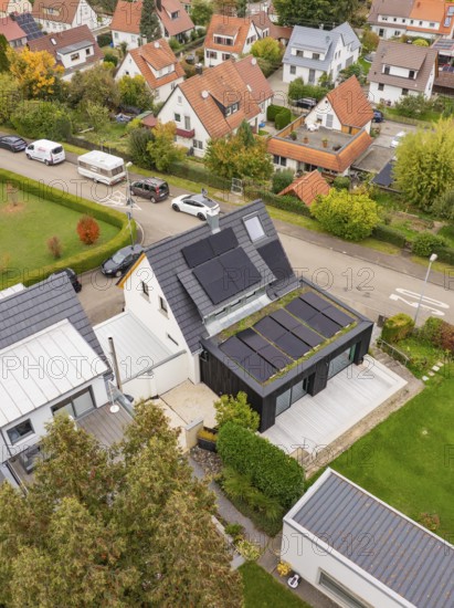 Top view shows PV modules and covered terrace at a modern extension with large wooden deck and garden, house renovation, climate renovation, Metzingen, Germany