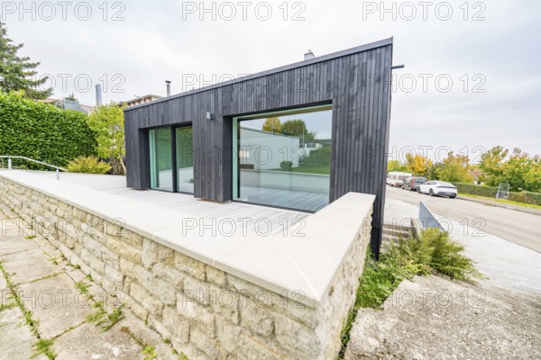 Contemporary extension with large glass front and terrace over a natural stone wall, house renovation, air-conditioning renovation, Metzingen, Germany