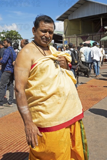 Hindu monk, 63 years old, in monk's robe, puja at the Chamundeswar Hindu temple on Chamundi Hill, Mysore or Mysore, Karnataka, India