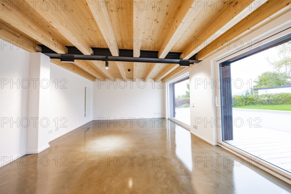 Large, modern room with wooden ceiling, black steel girders and polished concrete floor, open to the garden, house renovation, air-conditioning renovation, Metzingen, Germany