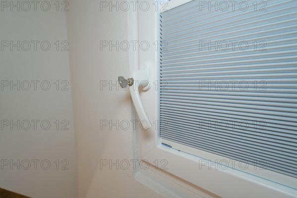 Detail of a lockable white window handle with integrated blind, house renovation, climate renovation, Metzingen, Germany