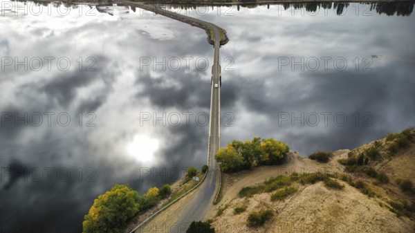 A long bridge over a shallow and calm lake on a cloudy day, photographed with a drone