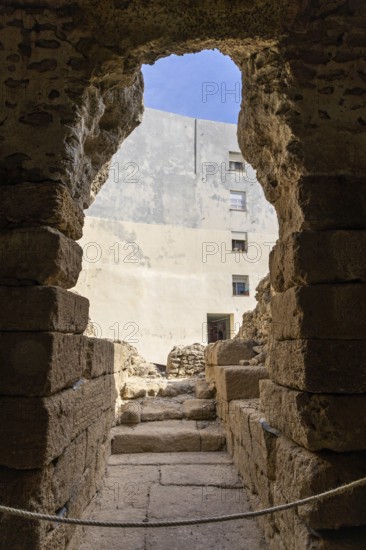 An old historic theatre in the middle of a town surrounded by houses. This landmark was photographed during the day. Teatro Romano de Cádiz, Andalusia, Spain