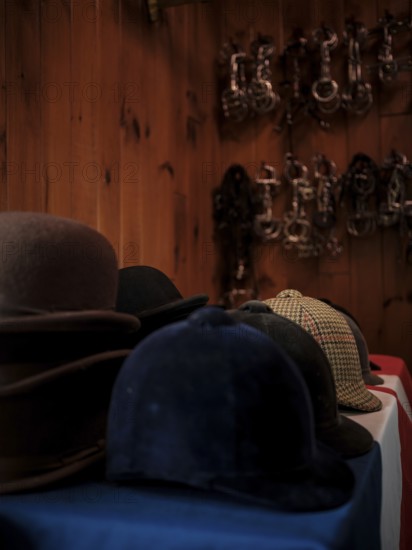 The tack room at the Toronto North York Hunt Club displaying a number of riding helmets, hats and a selection of horse bits hanging on the wall, on August 26, 2025 in Mulmer, Ontario, Canada