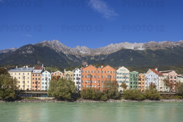 Colourful row of houses in Mariahilfstraße on the Inn River and mountains of the Karwendel North Range, Old Town, Innsbruck, Tyrol, Austria