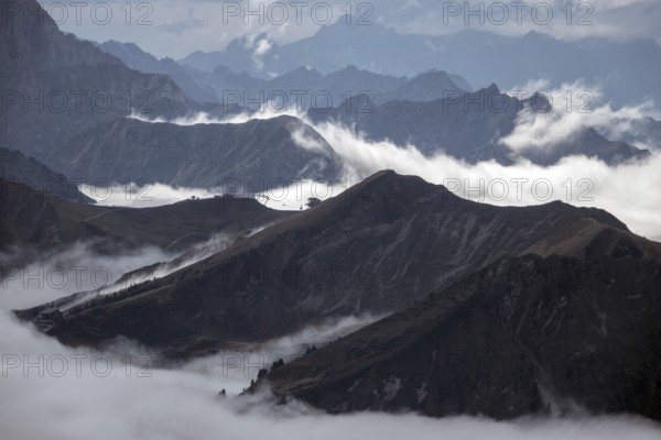 View from the Nebelhorn summit of the Allgäu Alps, in the middle of Fellhorn Horn with summit station, mountains rising from fog in the valley, Oberstdorf, Oberallgäu, Allgäu, Bavaria, Germany