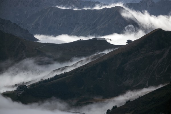 View from the Nebelhorn summit to mountains of the Allgäu Alps, in the middle of Fellhorn Horn with summit station and Kanzelwand cable car summit station, mountains rise from fog in the valley, Oberstdorf, Oberallgäu, Allgäu, Bavaria, Germany