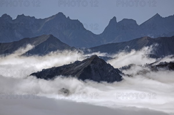 View from the Nebelhorn summit of the Allgäu Alps, in the middle of Walmendinger Horn, mountains rising from fog in the valley, Oberstdorf, Oberallgäu, Allgäu, Bavaria, Germany