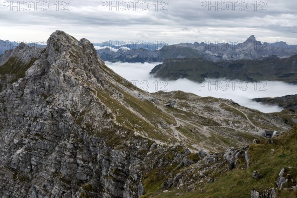View from the Nebelhorn summit to mountains of the Allgäu Alps, mountains rise from fog in the valley, Hintersteiner via ferrata on the left, Hochvogel in the back right, Oberallgäu, Allgäu, Bavaria, Germany