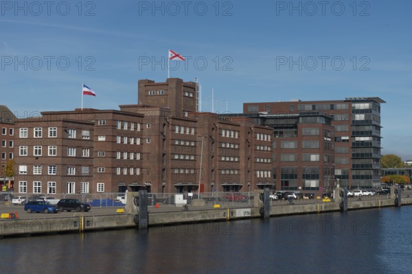 Former warehouse in the port of Kiel, apartments, services, red brick building, architecture, quay, flags, Kiel Fjord, Schleswig-Holstein, Germany